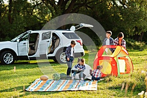 Family spending time together. Girl reading book outdoor