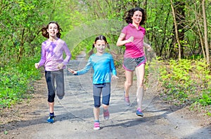 Family sport and fitness, happy active mother and kids jogging outdoors, running in forest, healthy lifestyle family