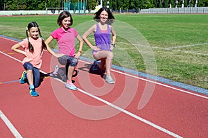 Family sport and fitness, happy mother and kids exercising and running on stadium track outdoors, active children