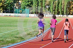 Family sport and fitness, happy mother and kids running on stadium track outdoors, children healthy active lifestyle