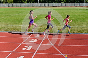 Family sport and fitness, happy mother and kids running on stadium track outdoors, children healthy active lifestyle