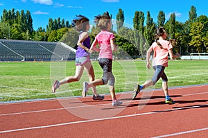 Family sport and fitness, happy mother and kids running on stadium track outdoors, children healthy lifestyle concept