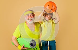 Family sport. Grandfather with yoga mat and child with Basketball ball. Grandpa and Grandson sporting.