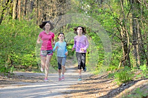 Family sport, happy active mother and kids jogging, running in forest