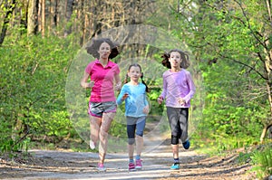 Family sport, happy active mother and kids jogging, running in forest