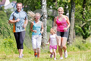 Family sport jogging through field