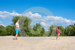 Family sports games on the beach. Father and daughter play badminton. Active healthy lifestyle concept