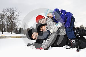 Family stacked in snow.