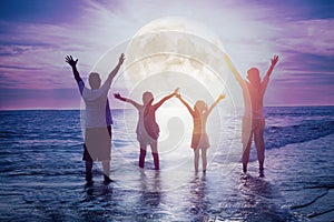 Family standing on beach and watching the moon.Celebrate Mid-autumn festival