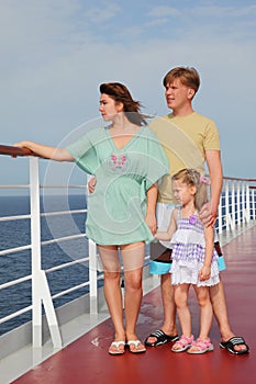 Family standing on cruise liner deck, full body