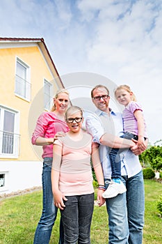 Family standing in front of home or house