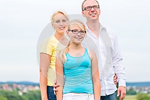 Family standing on grass of lawn or field