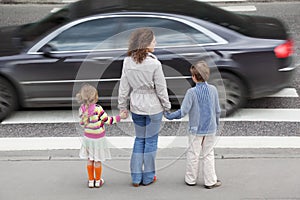 Family standing near cross road, behind