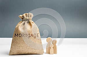 Family standing near the money bag with the word Mortgage. Loss of property for failure to pay mortgage rates. Loan for housing.