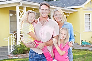 Family Standing Outside Suburban Home