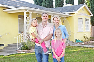 Family Standing Outside Suburban Home