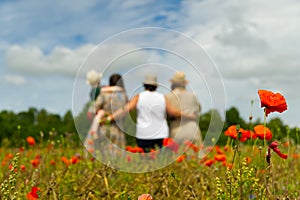 Family Standing In Poppy Field on sunny day, blured, selective focus.