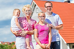 Family standing proud in front of home