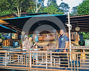 Family standing at the terrace from the wooden patio in Kuak Hill Resort in Lenggong