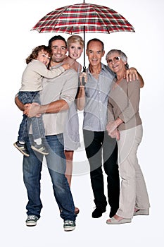 Family standing under umbrella