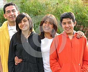 Family stands on grass against house