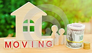 Family stands near the miniature house with money and the inscription `moving`. real estate concept. moving to another apartment,