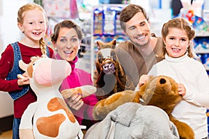 Family with stuffed elephant in toy store playing