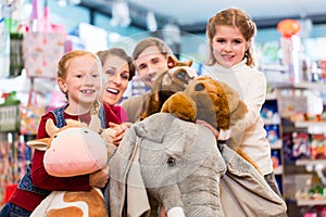 Family with stuffed elephant in toy store playing