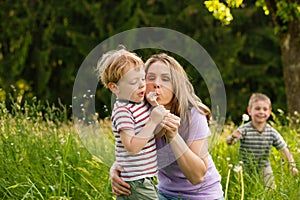 Family summer - blowing dandelion seeds