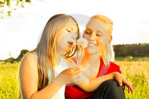 Family summer - blowing dandelion seeds