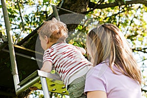 Family summer on ladder to tree house