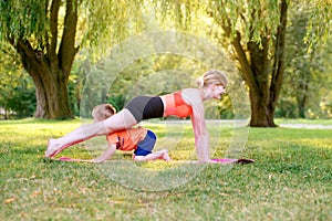 Family summer outdoor sport activity. Young Caucasian mother with child toddler boy doing workout yoga fitness in park. Woman mom