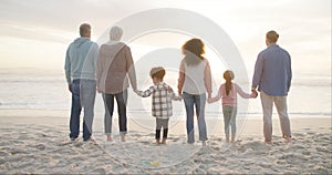 Family, sunset and beach with back view, holding hands or bonding on weekend with children. Generations, summer or