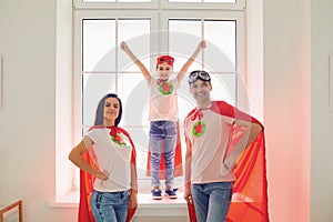 Family of superheroes. Happy mother father and kid daughter laughing in room