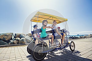 Family on a surrey bike ride along the coast of California