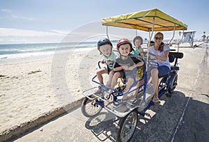 Family on a surrey bike ride along the coast of California