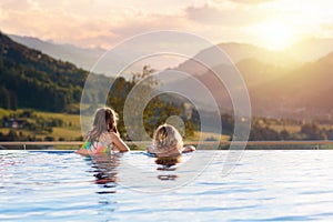 Family in swimming pool with mountain view photo