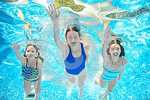 Family swims in pool under water, happy active mother and children have fun underwater, kids sport