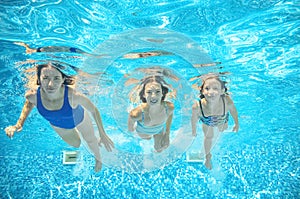 Family swims in pool under water, happy active mother and children have fun underwater, kids sport