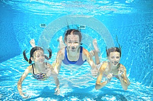 Family swims in pool underwater, happy active mother and children have fun