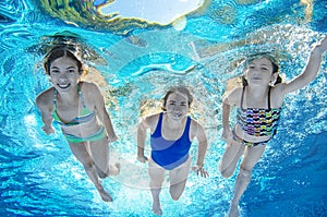 Family swims in pool underwater, happy active mother and children have fun under water, fitness and sport with kids