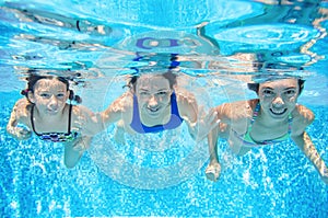 Family swims in pool underwater, happy active mother and children have fun under water, fitness and sport with kids