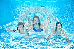 Family swims in pool underwater, happy active mother and children have fun under water, fitness and sport with kids