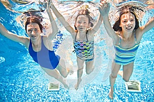 Family swims in swimming pool underwater, happy active mother and children have fun under water, fitness and sport with kids