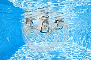 Family swims in swimming pool underwater, happy active mother and children have fun under water, fitness and sport with kids