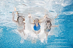Family swims in swimming pool underwater, happy active mother and children have fun under water, fitness and sport with kids
