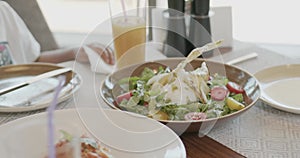 A family at a table in a restaurant of an expensive luxury hotel. Salads, pasta, wine glasses with juice and cocktails