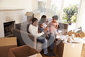 Family Take A Break On Sofa With Pizza On Moving Day