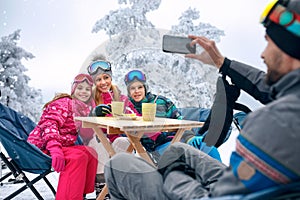 Family takes tea break during skiing on the mountain