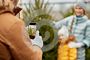 Family taking picture of christmas tree at market